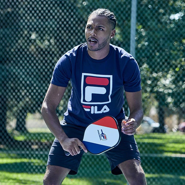 Man holding pickleball paddle outside